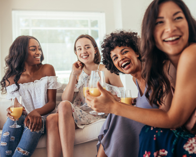 smiling group of girls over orange juice at party